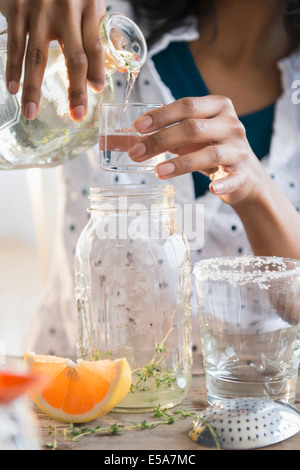 Mixed race woman making cocktail Stock Photo
