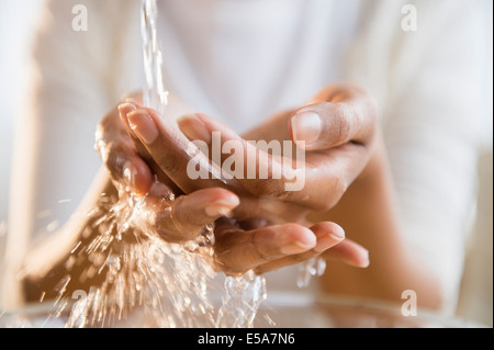 Mixed race woman washing her hands Stock Photo