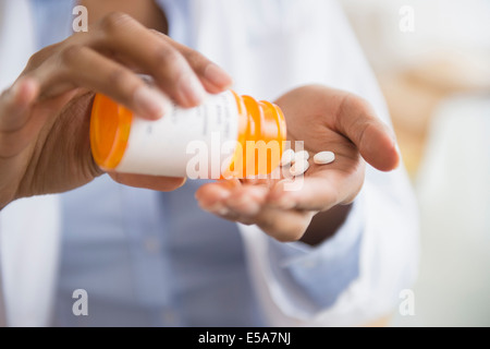 Mixed race doctor taking medication Stock Photo