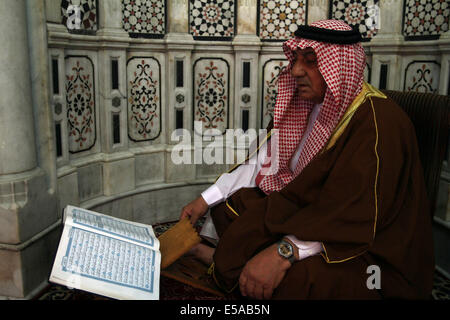 Damascus, Syria. 25th July, 2014. A Syrian man reads the Muslim's holy book, Quran, at Umayyad Mosque in the old city of Damascus, Syria on Friday, July 25, 2014, the last Friday of the Muslims holy month of Ramadan during which Muslims refrain from eating, drinking, smoking from sunrise to sunset. Credit:  Bassem Tellawi/Xinhua/Alamy Live News Stock Photo