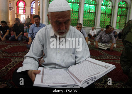 Damascus, Syria. 25th July, 2014. Syrians read the Muslim's holy book, Quran, at Umayyad Mosque in the old city of Damascus, Syria on Friday, July 25, 2014, the last Friday of the Muslims holy month of Ramadan during which Muslims refrain from eating, drinking, smoking from sunrise to sunset. Credit:  Bassem Tellawi/Xinhua/Alamy Live News Stock Photo