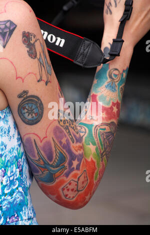 coloured tattoos covering womans arm Stock Photo