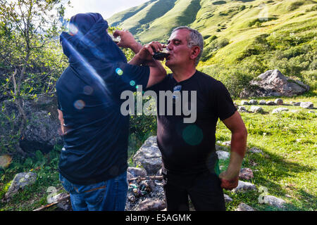 Georgian men toasting and drinking wine at Enguri valley near Ushguli. Svaneti region, Georgia. Stock Photo