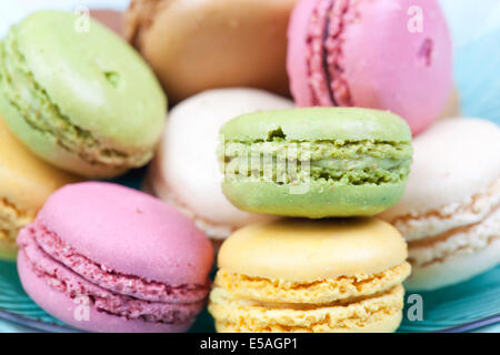 assorted colorful macaroons in blue glass bowl. Stock Photo