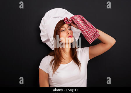 Very tired female chef wiping face from sweat, Debica, Poland Stock Photo