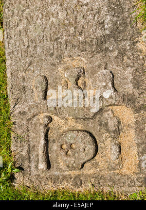 CARVED SKULL BONES HOUR GLASS AND DEAD BELL ON A TOMB  IN MORTLACH CEMETERY DUFFTOWN SCOTLAND Stock Photo