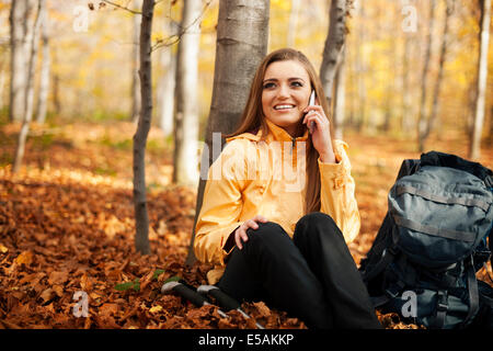 Hiker woman resting and talking on mobile phone, Debica, Poland Stock Photo
