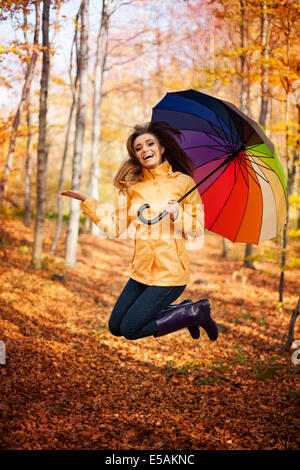 Young woman jumping during the rainy day at autumn, Debica, Poland Stock Photo