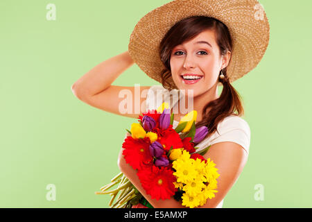 Smiling brunet woman with hat and spring flower, Debica, Poland Stock Photo