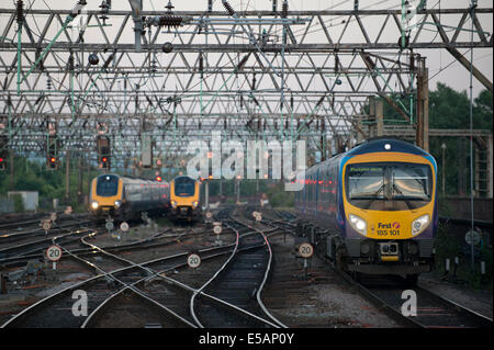 A First TransPennine Express train enters Manchester Piccadilly Rail Station as a Cross Country and Arriva train depart. Stock Photo