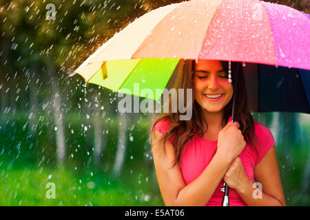 Beautiful woman under rainbow umbrella Debica, Poland Stock Photo