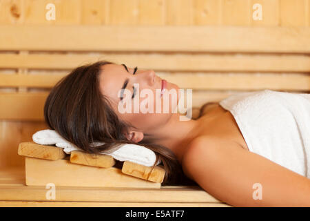 Woman wrapped in white towel laying in sauna  Debica, Poland Stock Photo