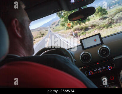 Man demonstrating the use of Android Auto technology device using voice commands to navigate and control entertainment systems Stock Photo