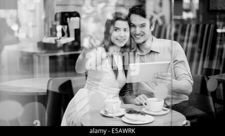 Happy couple in cafe holding digital tablet  Debica, Poland Stock Photo