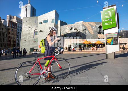 Melbourne Australia,Federation Square,St. Kilda Road,woman female women,teen teens teenager teenagers,girl girls,child children,bicycling,biker bikers Stock Photo
