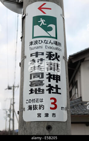 A tsunami evacuation sign in Kyoto prefecture, Japan. The sign is positioned about 50 metres from the coast of the Japan Sea. Stock Photo