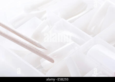 Manicure tools , Orange wood sticks for removal cuticle on white plastic tips background Stock Photo