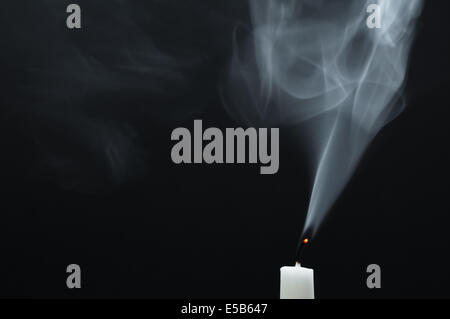 A white candle is smoking after it is extinguished Stock Photo