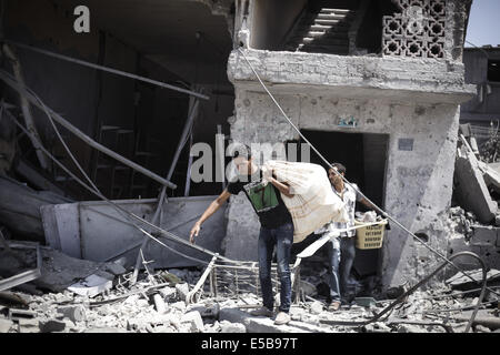 Gaza City, Palestinian Territories. 26th July, 2014. Palestinians inspect destroyed houses in the Shejaia neighbourhood, which witnesses said was heavily hit by Israeli shelling and air strikes during an Israeli offensive, in Gaza City. A 12-hour humanitarian truce went into effect on Saturday after Israel and Palestinian militant groups in the Gaza Strip agreed to a U.N. request for a pause in fighting and efforts proceeded to secure a long-term ceasefire moved ahead. Credit:  Ahmed Hjazy/Pacific Press/Alamy Live News Stock Photo