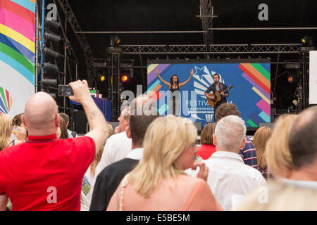 A large group watch a man and woman perform on stage, singing and performing on acoustic guitar, West End Festival, Glasgow, Scotland, UK, 2014 Stock Photo