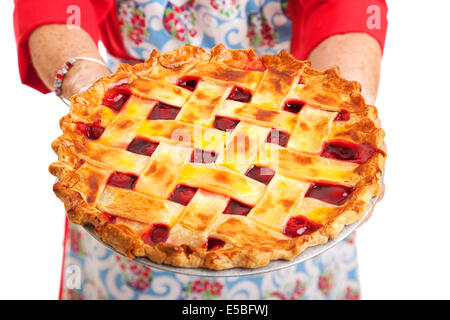Closeup of a homemade cherry pie being held by a stereotypical grandma.  Isolated on white. Stock Photo