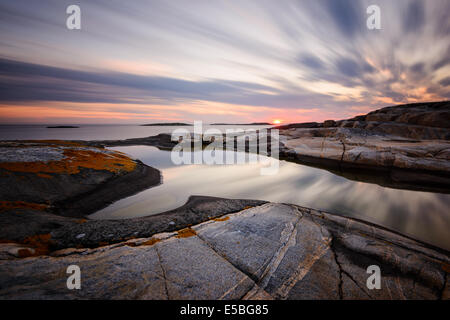 Rocky coast with dramatic sky during sunset Stock Photo