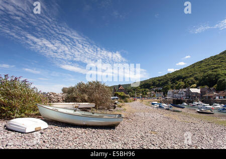 Small boats lay on the pebble beach at Porlock Weir, a popular tourist destination in the South West of England. Stock Photo