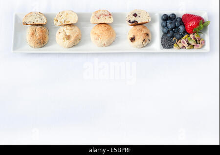 A set of four cookies sliced open plated on a white dish next to the main ingredients that were used in each one. Stock Photo