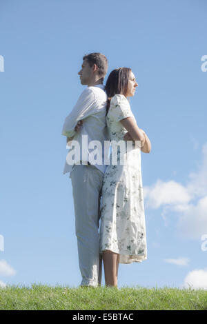 a couple back to back on a meadow Stock Photo