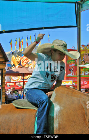 Santa Rosa, California, USA. 26th July, 2014. Latino boy rides mechancal bull at the Sonoma County Fair Credit:  Bob Kreisel/Alamy Live News Stock Photo