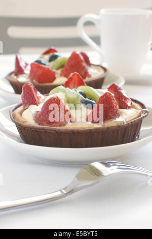 Fruit tarts made with sweet pastry creme patissiere and strawberries, blueberries and kiwi fruit Stock Photo