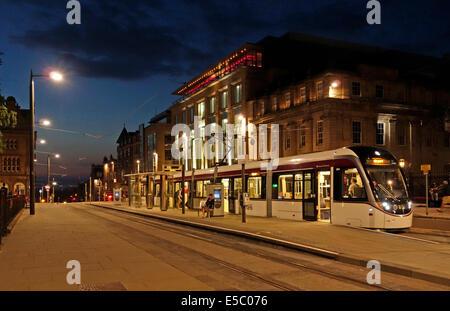 Evening image of Edinburgh tram at Andrew Square Edinburgh Scotland with Harvey Nichols store in the background Stock Photo