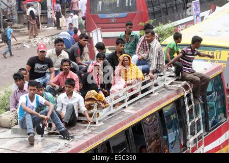 Dhaka, Bangladesh. 27th July 2014 People stay on the rooftop of a homebound bus in Dhaka, capital of Bangladesh. As the end of Ramadan approaches, bus, and train terminals witnessed a mad rush, as people streamed out of Dhaka on Saturday, defying all the dangers, and hassles to journey home to celebrate Eid-ul-Fitr with their loved ones in outlying districts. Stock Photo