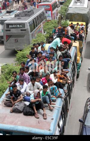 Dhaka, Bangladesh. 27th July 2014 People stay on the rooftop of a homebound bus in Dhaka, capital of Bangladesh. As the end of Ramadan approaches, bus, and train terminals witnessed a mad rush, as people streamed out of Dhaka on Saturday, defying all the dangers, and hassles to journey home to celebrate Eid-ul-Fitr with their loved ones in outlying districts. Stock Photo