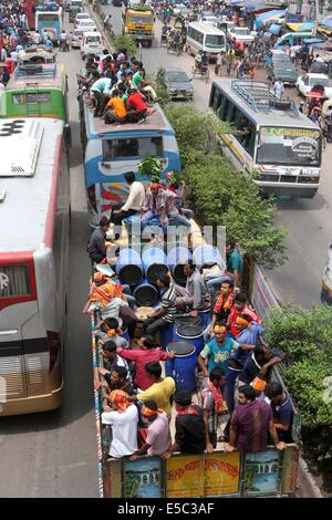 Dhaka, Bangladesh. 27th July 2014 People stay on the rooftop of a homebound bus in Dhaka, capital of Bangladesh. As the end of Ramadan approaches, bus, and train terminals witnessed a mad rush, as people streamed out of Dhaka on Saturday, defying all the dangers, and hassles to journey home to celebrate Eid-ul-Fitr with their loved ones in outlying districts. Stock Photo