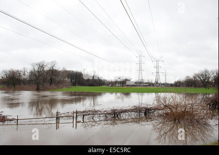 A set of power lines span the flood that engulfed the area with flood damage. Stock Photo