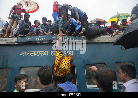 Dhaka, Bangladesh. 27th July, 2014. People climb onto the roof of an overcrowded train as they travel back to their homes ahead of Eid Al-Fitr celebrations at the Gazipur Railway Station in Dhaka, Bangladesh. Millions of city dwellers travel to villages to celebrate the festival which marks the end of the Muslim fasting month of Ramadan. Credit:  Probal Rashid/ZUMA Wire/Alamy Live News Stock Photo