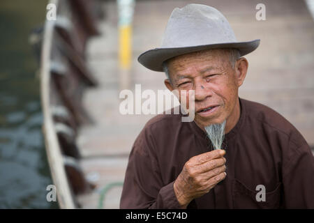 Vietnamese man with long beard in row boat in HoiAn canal Stock Photo