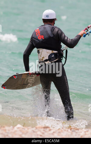 LAKE OF SANTA CROCE, ITALY - JULY 13, 2014: Kitesurfer launches his kite in the lake of Santa Croce Stock Photo