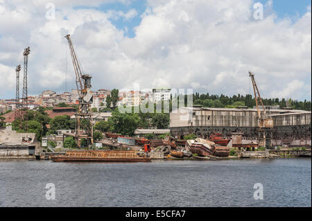 Old abandoned derelict dockyards by large river in city Stock Photo