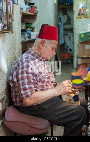 The last working cobbler in his shop at the old market in Nazareth, Israel Stock Photo