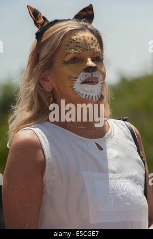 A woman with her face painted as a leopard /  cheetah,  in the 2014 Summer Solstice Parade, Santa Barbara, California Stock Photo