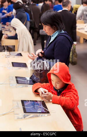 People trying new iPhones at Apple store in Ginza, Tokyo, Japan 2014 Stock Photo
