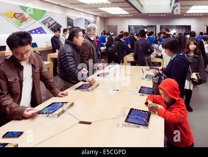 People at Apple store trying new iPhones. Ginza, Tokyo, Japan 2014 Stock Photo