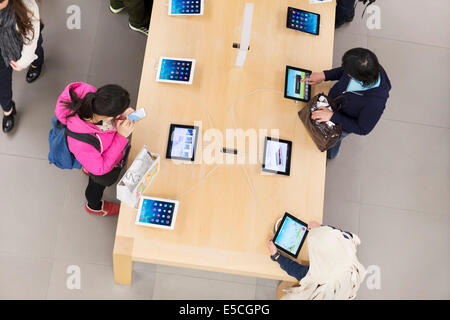 People at Apple store trying new iPad tablets. Ginza, Tokyo, Japan 2014 Stock Photo