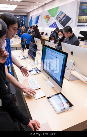 People at Apple store trying new technology. Ginza, Tokyo, Japan 2014 Stock Photo