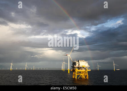 A rainbow over wind turbines on the Gwynt y Mor Wind Farm off the coast of North Wales during the Construction Phase in 2014. Stock Photo
