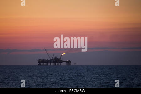 The flare of the Douglas Platform Complex seen from the Gwynt y Mor Wind Farm off the coast of North Wales. Stock Photo
