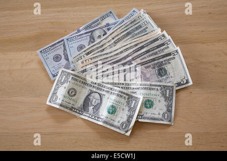 A pile of various American dollar bills on a table. Stock Photo