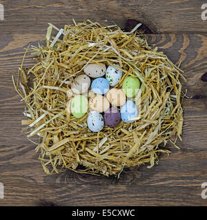 Straw nest full of candy covered easter eggs Stock Photo
